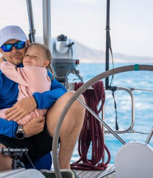 Father and daughter control sailing boat in the sea on boat or yacht. Family, adventure and skipper concept. High quality photo
